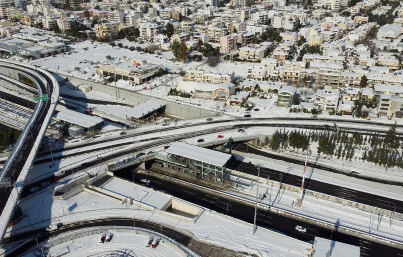 Aerial view of Athens city with snow-covered roads and buildings in winter.